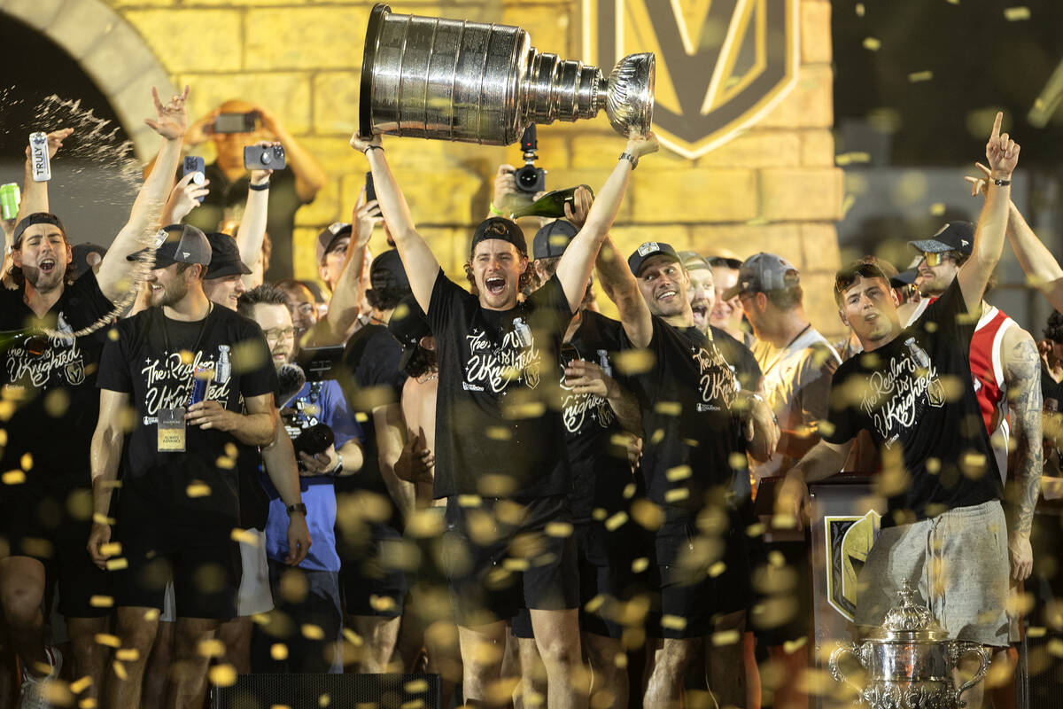 Golden Knights center Brett Howden, center, cheers with the Stanley Cup as confetti rains down ...