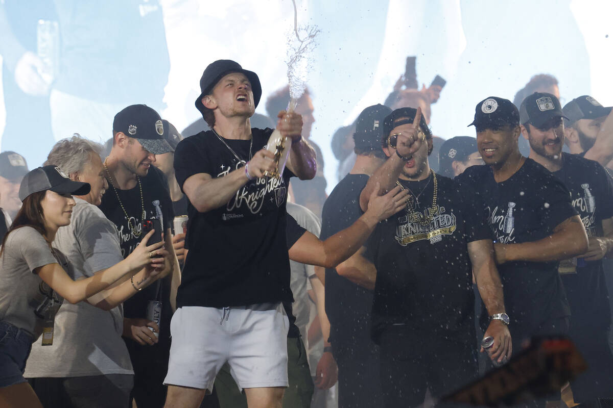 Golden Knights center Jack Eichel , left, shakes champagne with his teammates during a rally at ...