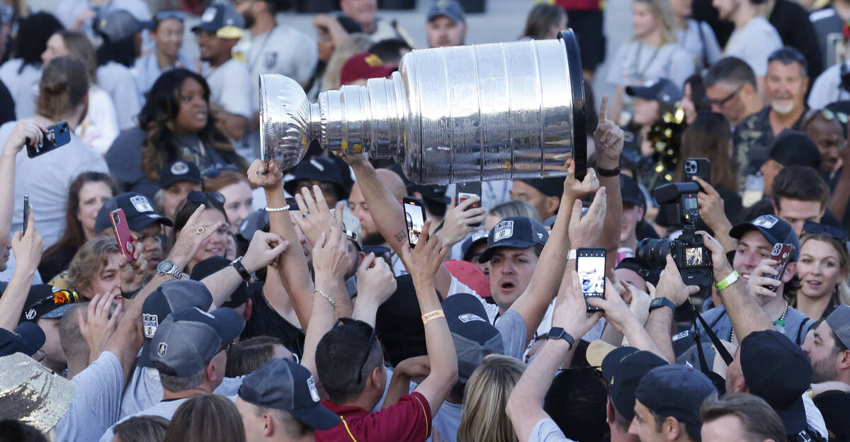 People hold up the Stanley Cup after the Golden Knights’ NHL hockey Stanley Cup victory ...