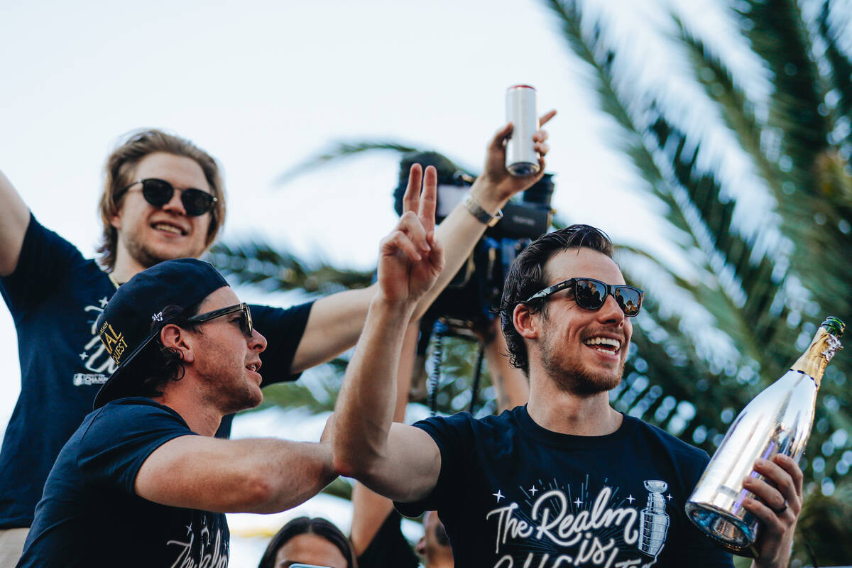 Golden knights forward Jonathan Marchessault waves to the crowd wile drinking a bottle of champ ...