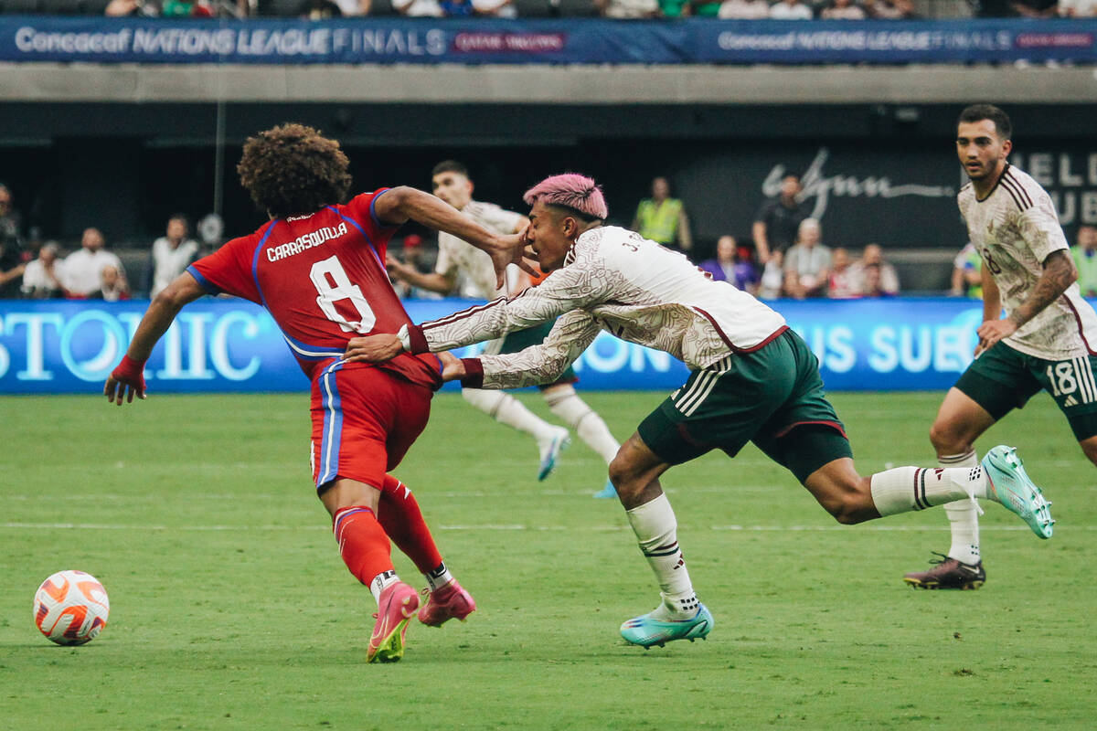 Mexico’s Julian Araujo pulls at the jersey of Panama’s Adalberto Carrasquilla (8) ...