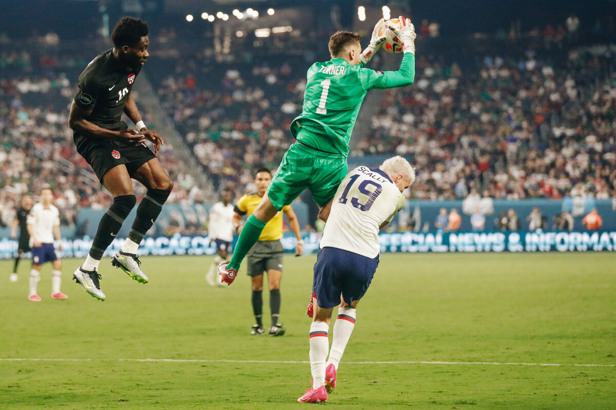 Team USA goalie Matt Turner (1) jumps in the air to grab the ball and crashes into teammate Joe ...