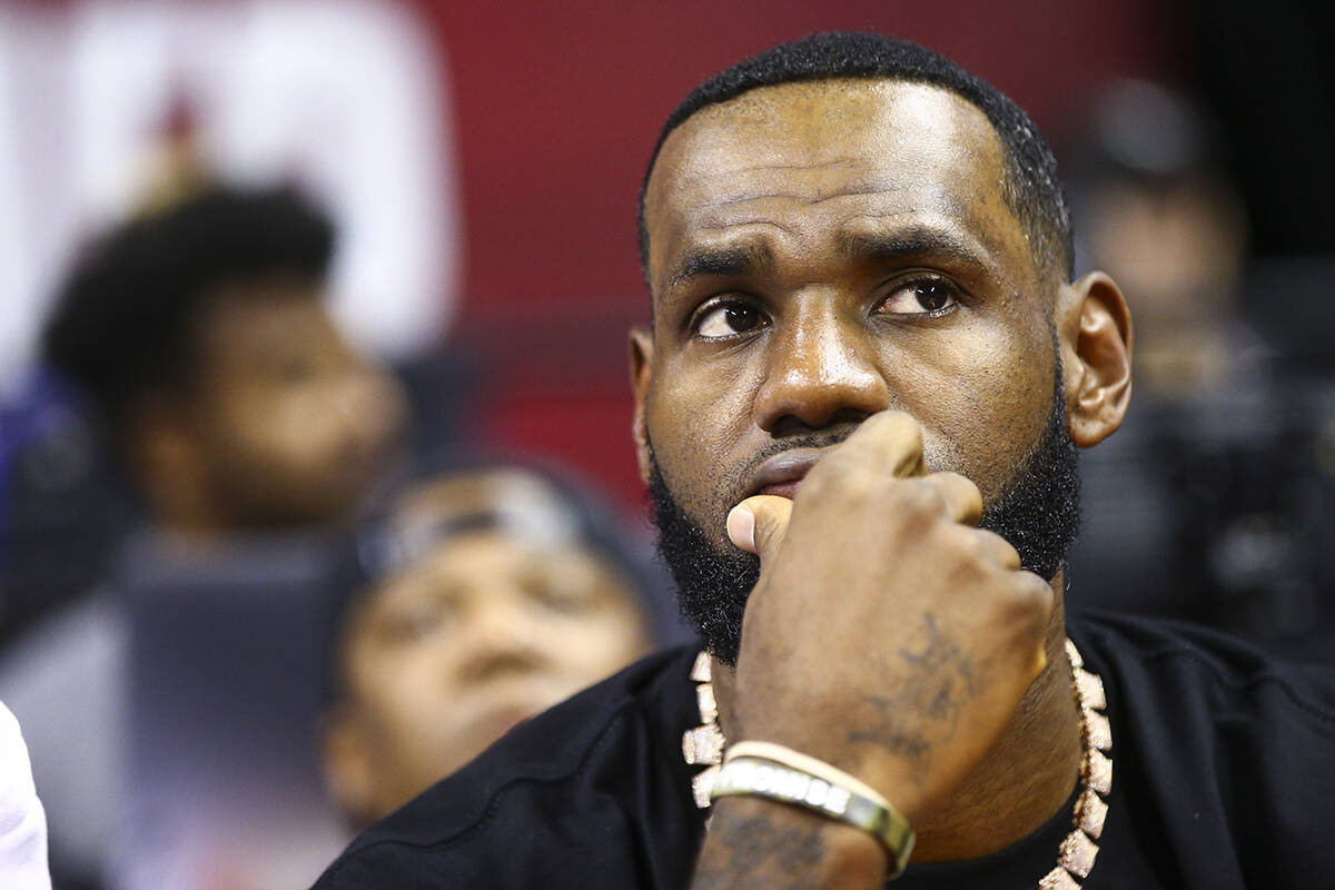 Los Angeles Lakers' LeBron James sits courtside before the start of a game between the Los Ange ...