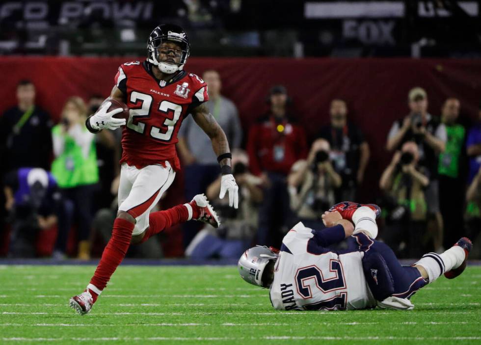 Atlanta Falcons' Robert Alford, left, runs past New England Patriots' Tom Brady for a touchdown ...