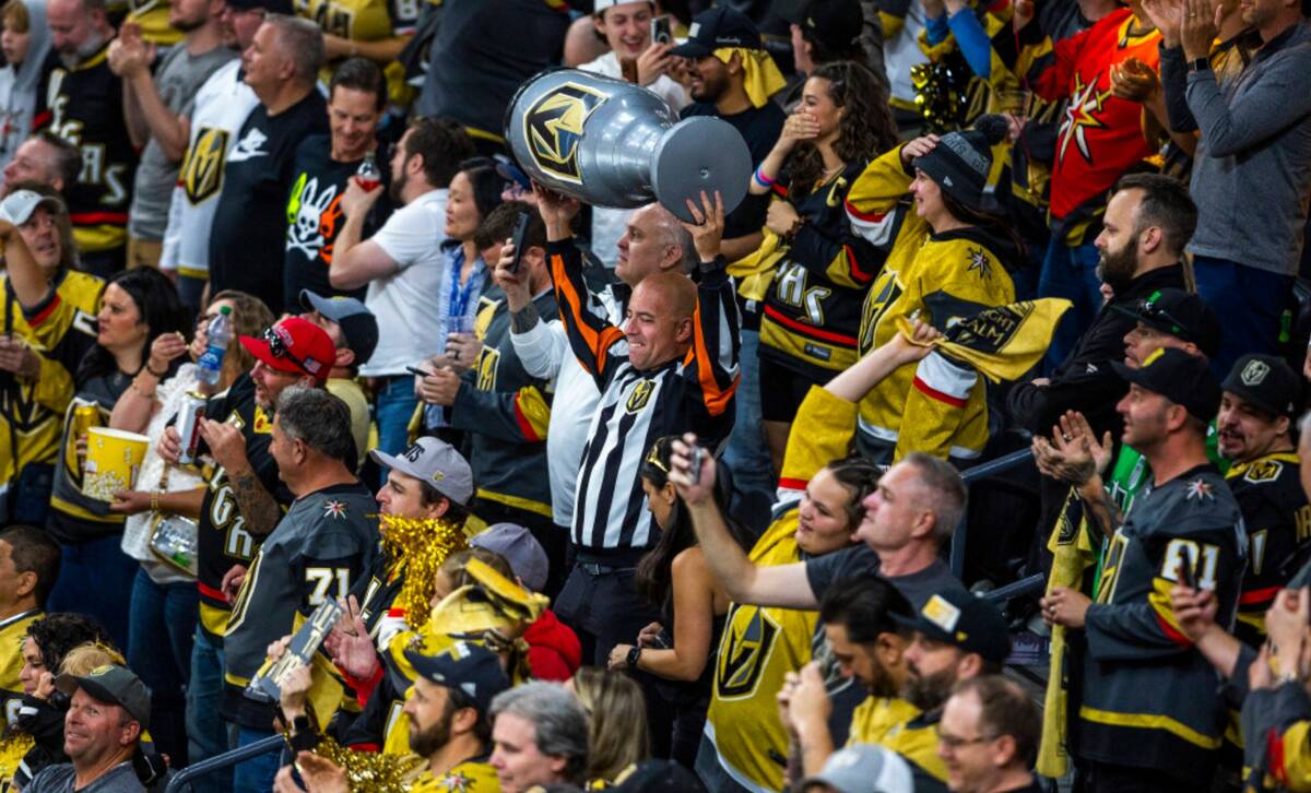 Golden Knights fans, one with a blow up Stanley Cup trophy, celebrate during Game 5 of the Stan ...