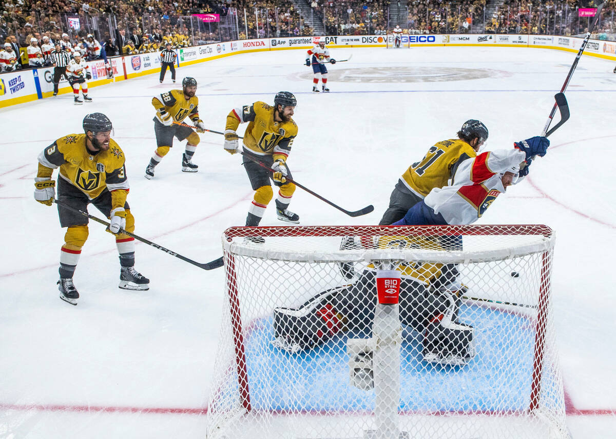 Golden Knights right wing Mark Stone (61) drives Florida Panthers center Nick Cousins (21) away ...