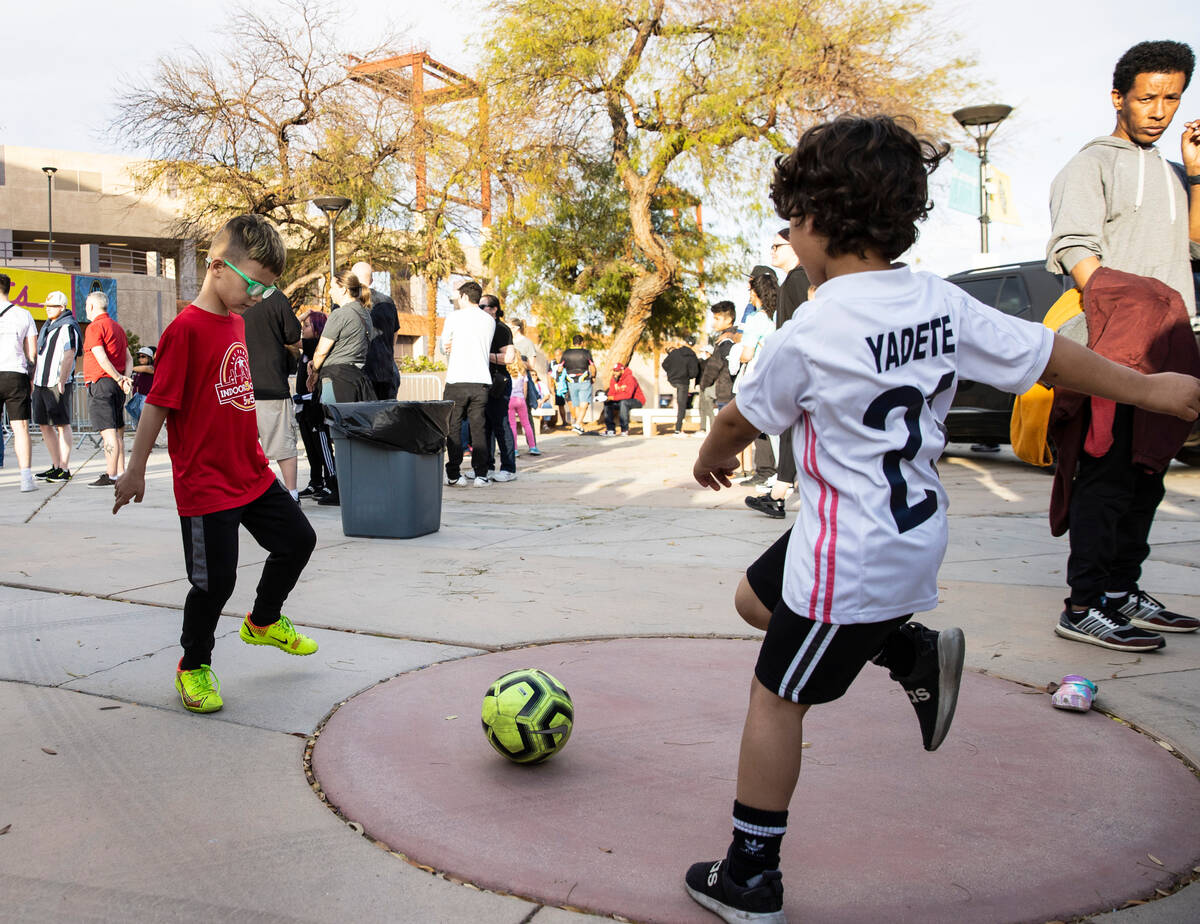 Emil Maslesa, 6, left, plays soccer with Elias Yadete, 5, outside of Cashman Field as fans line ...