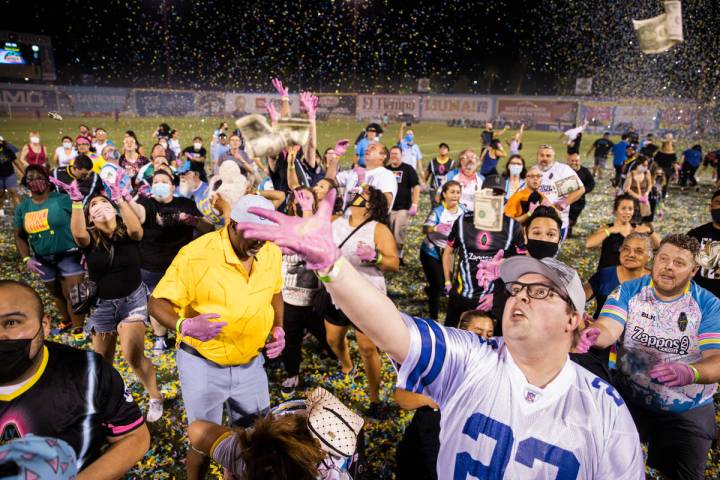 FILE - People scramble for money during the annual “$5,000 Cash Drop presented by Jarritos” ...