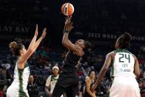 Las Vegas Aces guard Chelsea Gray (12) shoots against Seattle Storm guard Kia Nurse, left, and ...