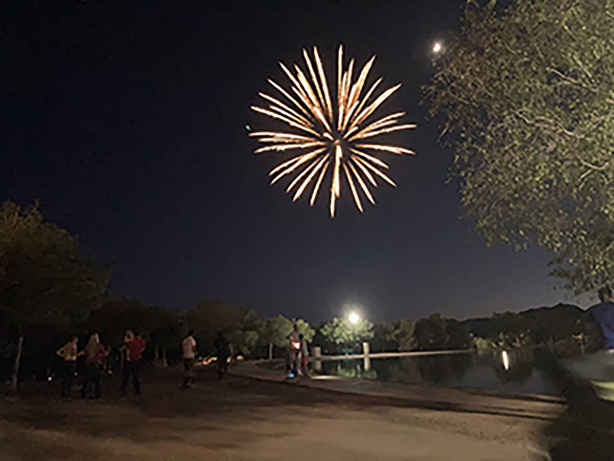 Fireworks light up the night sky on the Fourth of July overhead Veterans' Memorial Park to fini ...