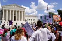 Demonstrators hold signs as they rally outside the Supreme Court building during the Women's Ma ...