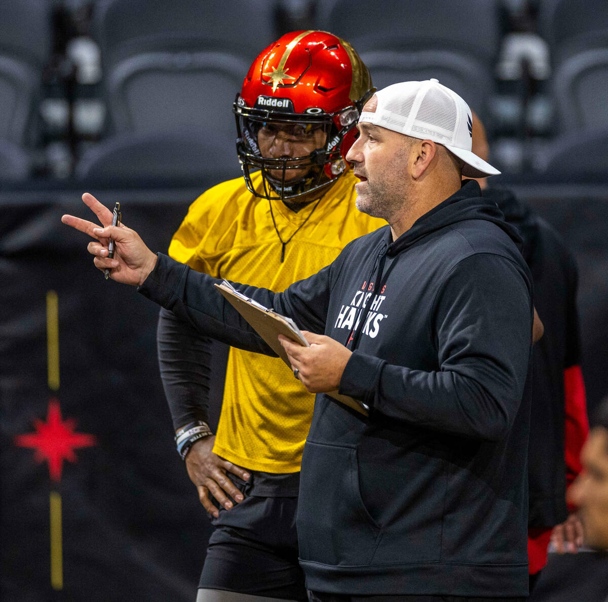 Vegas Knight Hawks head coach Mike Davis talks with his quarterback Daquan Neal during practice ...