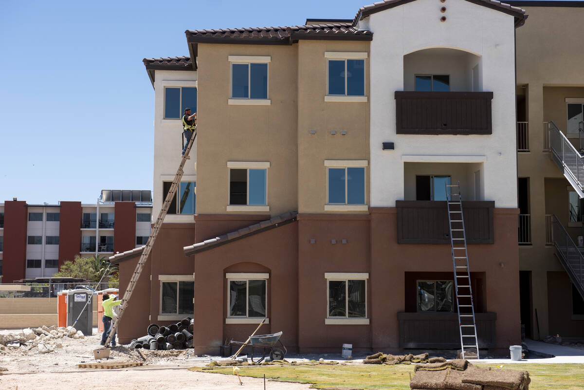 Workers put the finishing touches on a building at the Decatur Commons affordable housing compl ...