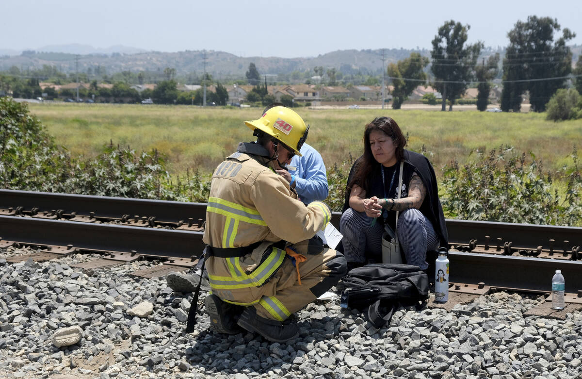 An Oxnard Fire Department firefighter checks out passengers after their Amtrak train derailed i ...