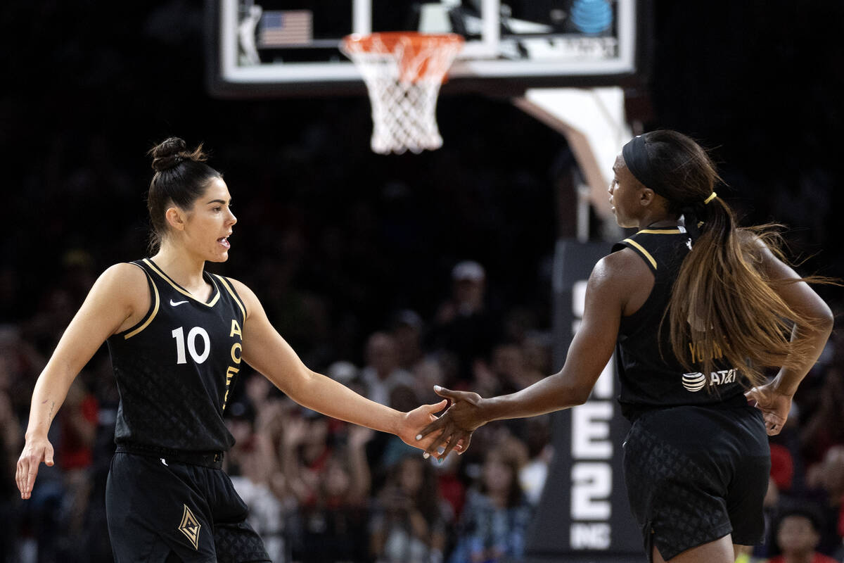 Las Vegas Aces guard Kelsey Plum (10) and guard Jackie Young (0) slap hands after Young scored ...