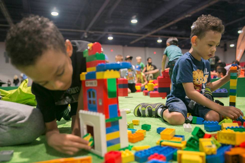 Deon Shepherd, 5, kiri, dan saudara kembarnya Ason Shepherd, 5, bermain di lubang LEGO selama Brick ...