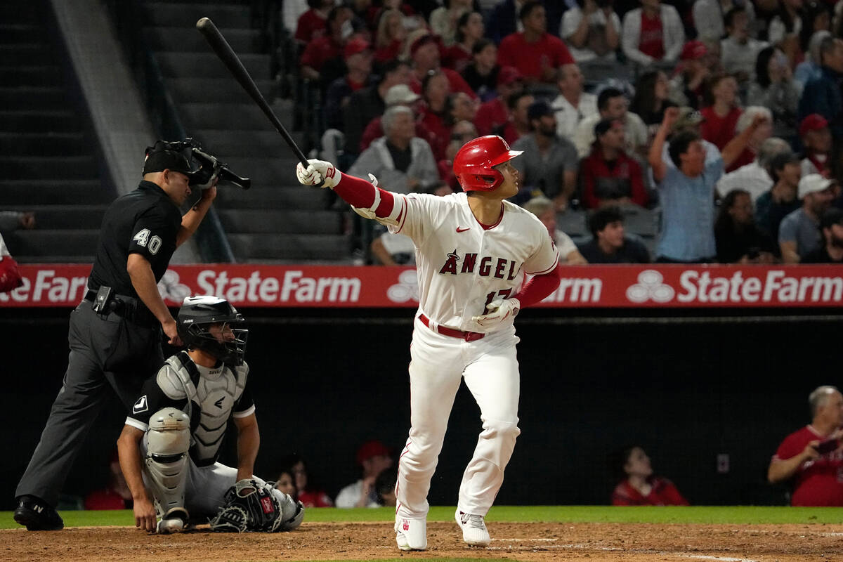 Los Angeles Angels' Shohei Ohtani, right, heads to first after hitting a solo home run as Chica ...