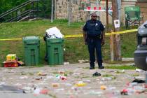 A police officer stands in the area of a mass shooting incident in the Southern District of Bal ...