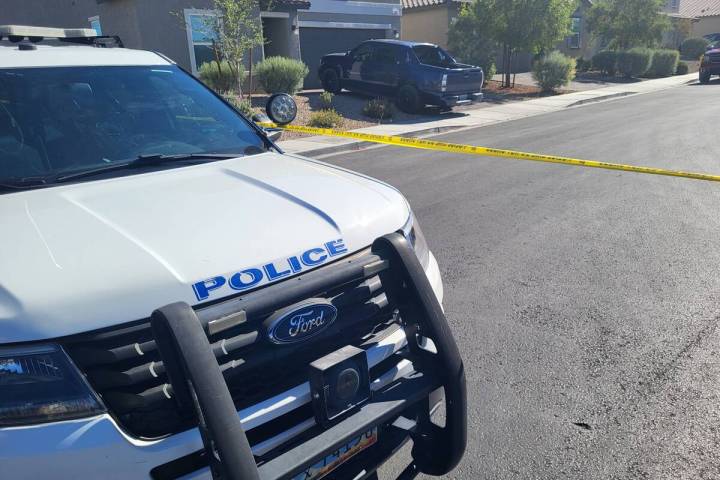 A North Las Vegas police vehicle is seen next to police tape cordoning off a crime scene at a h ...