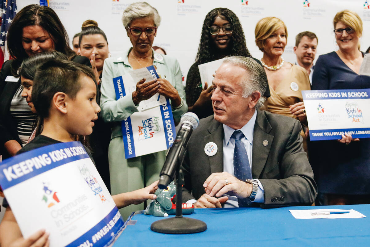 Nevada Gov. Joe Lombardo speaks to a child about his dinosaur toy after signing the Keeping Kid ...