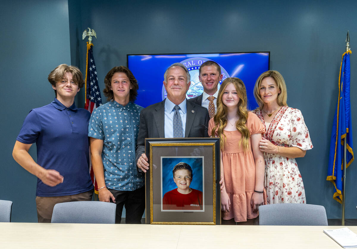 Nevada Gov. Joe Lombardo holds a photo of Rex Patchett joined by his family members after condu ...