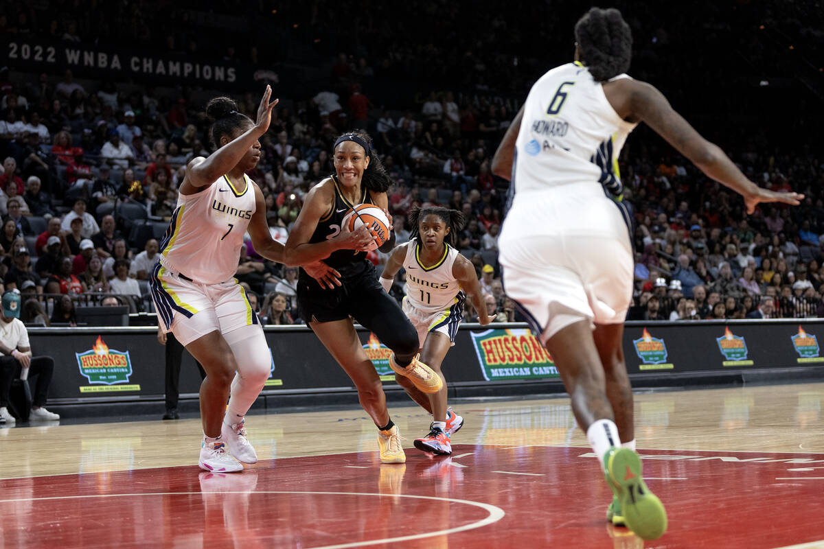 Las Vegas Aces guard Riquna Williams (2) drives toward the hoop between Dallas Wings center Tea ...