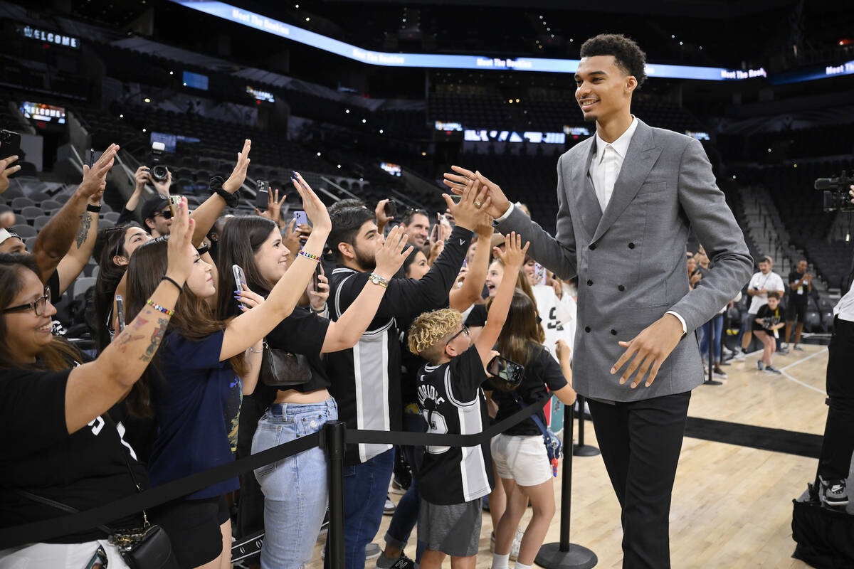 San Antonio Spurs' Victor Wembanyama, the No. 1 draft pick, greets fans before an NBA basketbal ...