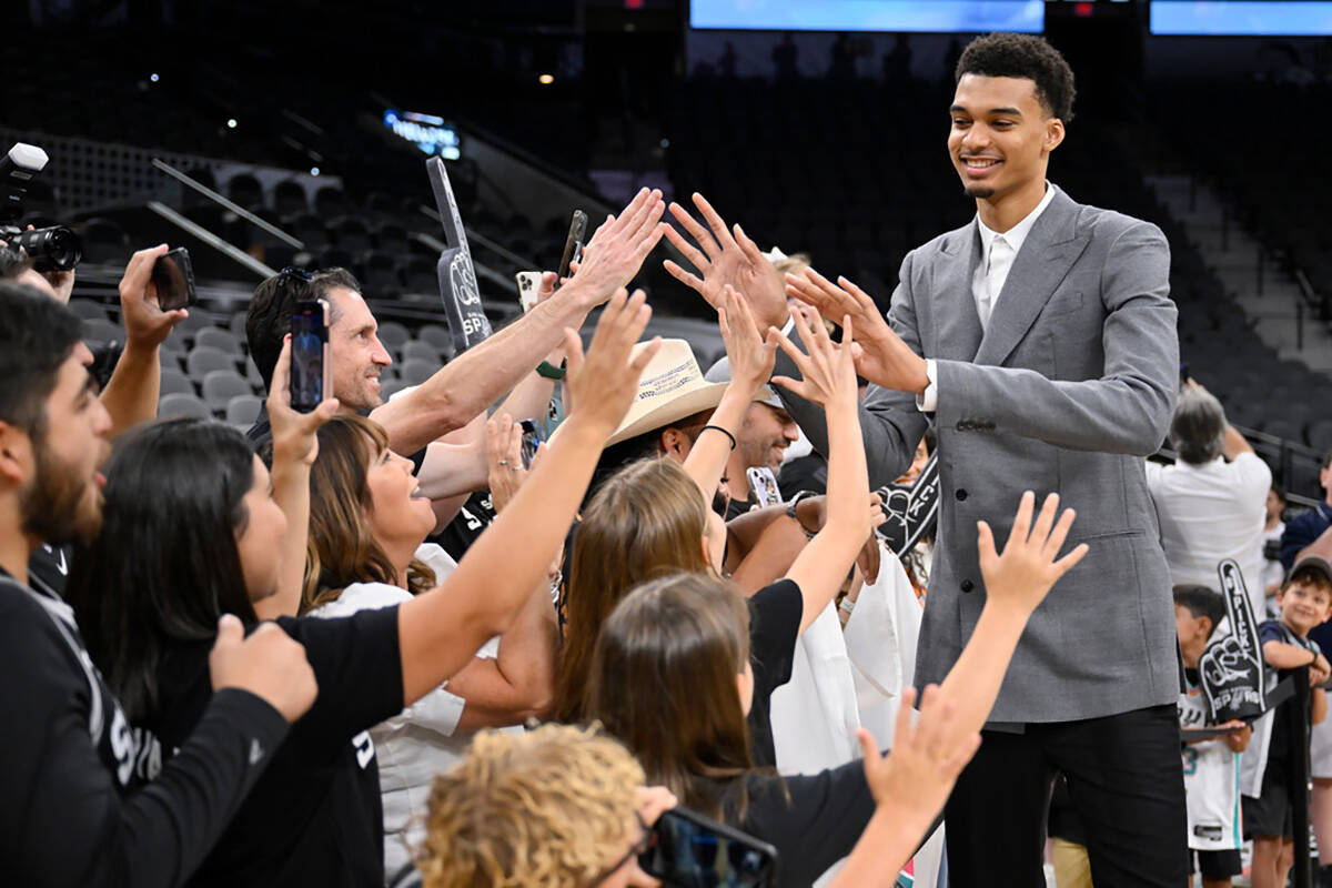 San Antonio Spurs' Victor Wembanyama, the No. 1 draft pick, greets fans before an NBA basketbal ...