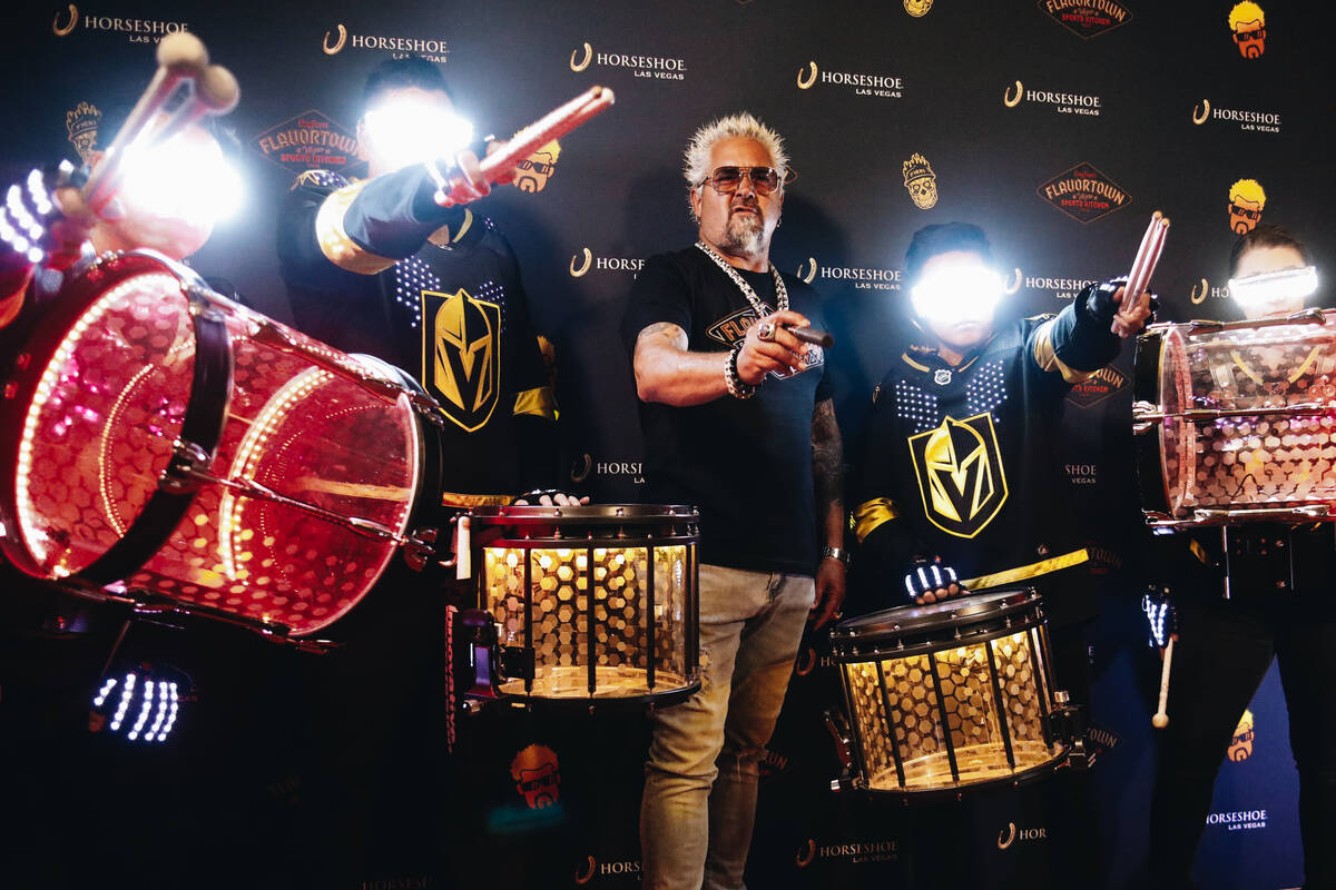 Guy Fieri poses for photos with the Drumbots, the drum line for the Golden Knights, during a gr ...