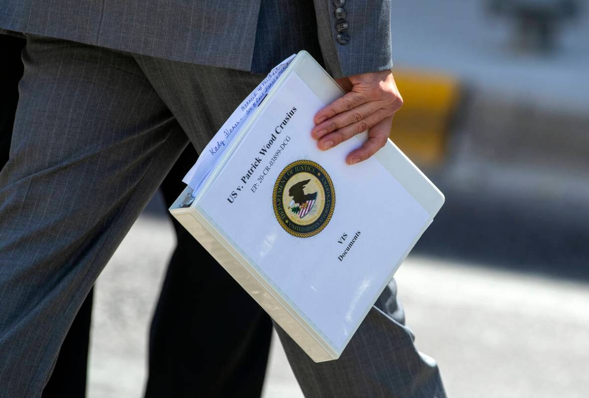 Federal prosecutor Ian Martinez Hanna holds a Victim Impact Statement documents binder while wa ...