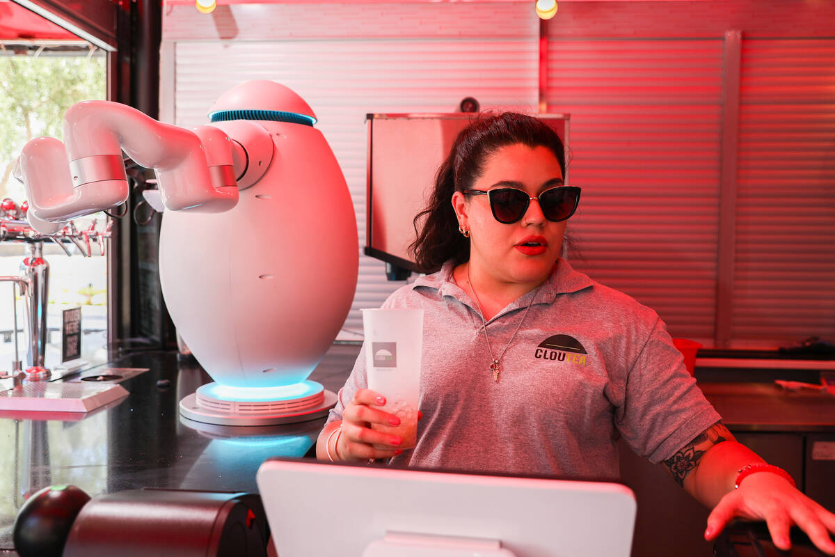 Paola Valdez first takes customer’s orders then passes a cup to Adam the robot who then ...