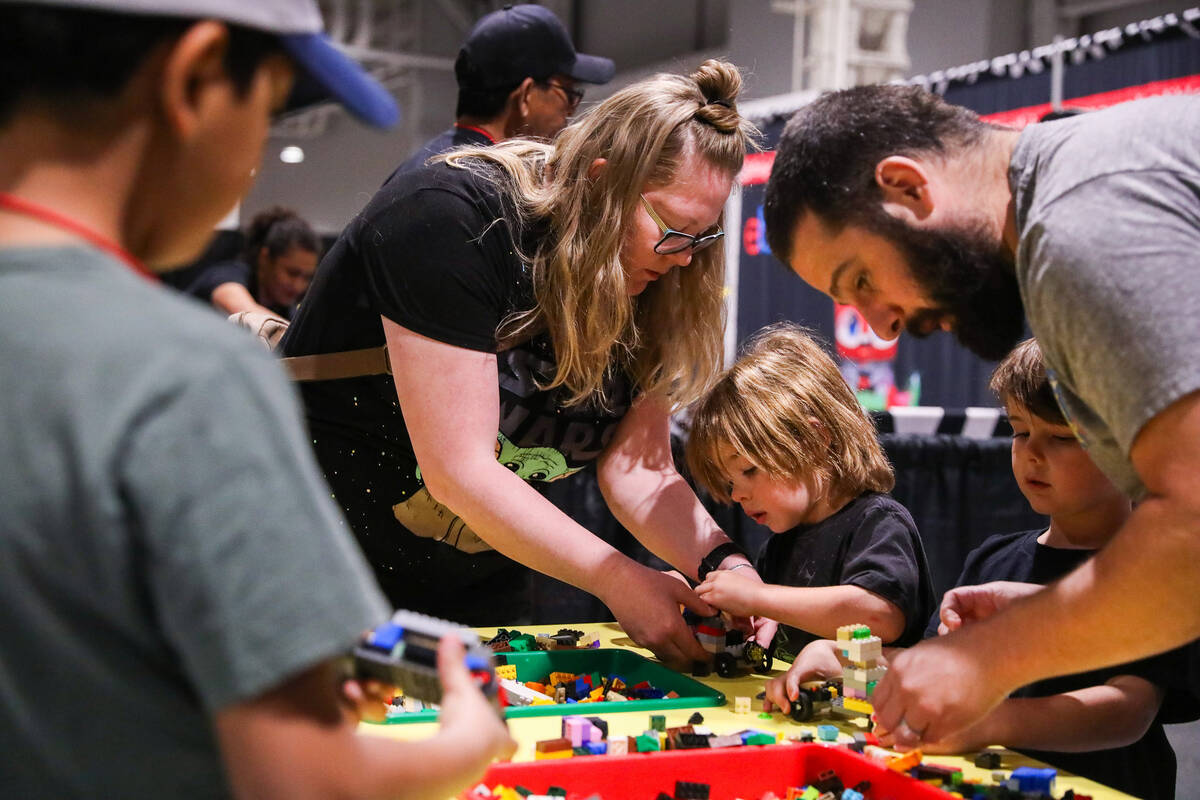 Emily Kuritz and Evan Kuritz assemble a LEGO car with their children Cooper Kuritz, 5, second l ...