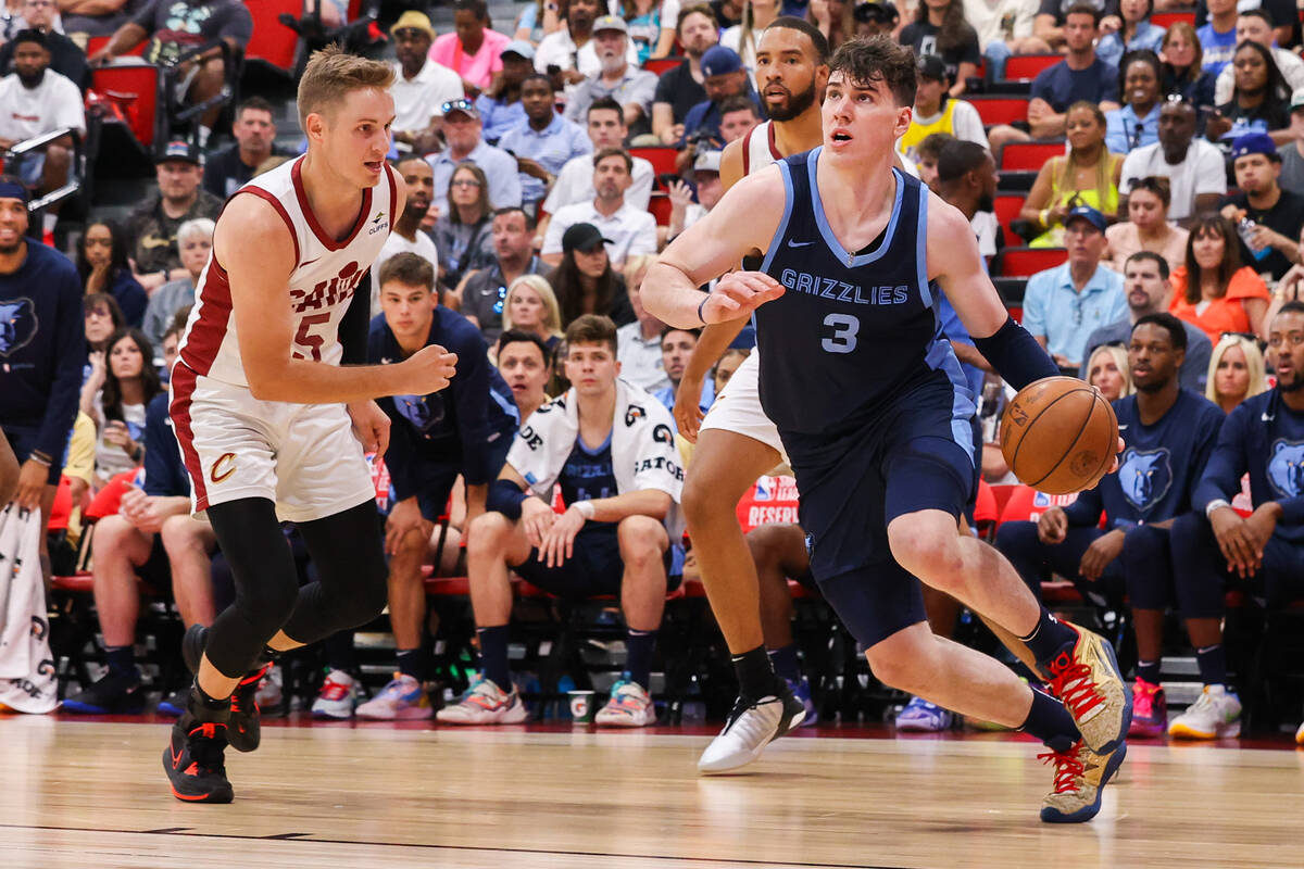 Memphis Grizzlies forward Jake LaRavia (3) drives the ball around Cleveland Cavaliers guard Sam ...