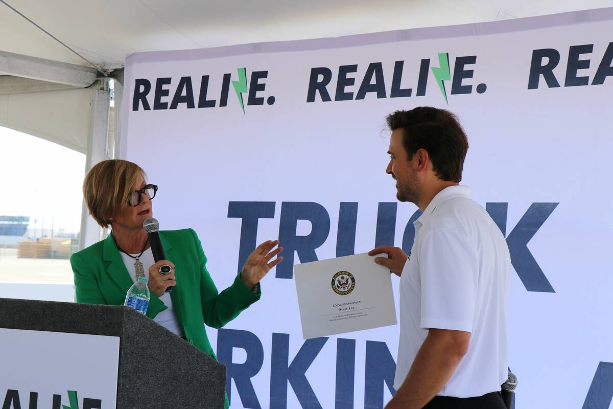 Rep. Susie Lee gives Realize CEO Cody Horchak a certificate of congressional recognition for op ...