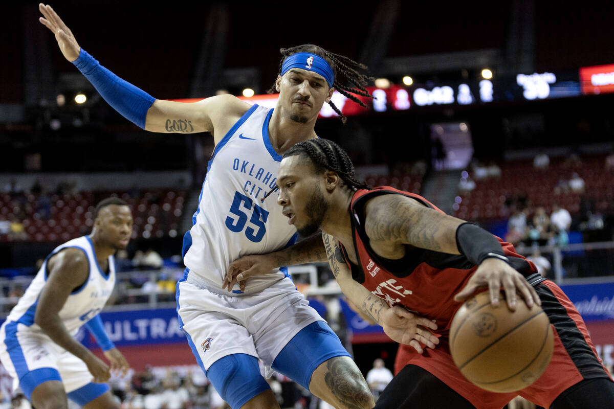 Houston Rockets forward Cam Whitmore, right, drives around Oklahoma City Thunder guard Caleb Mc ...