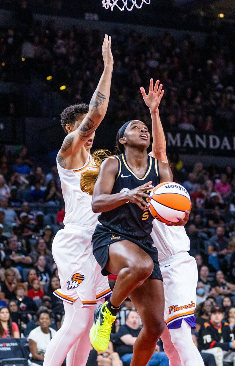 Aces guard Jackie Young (0) looks to shoot a reverse layup past Phoenix Mercury center Brittney ...