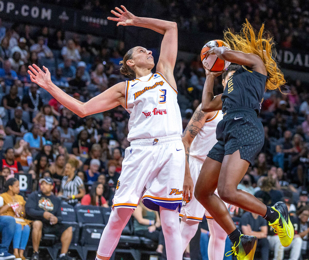 Aces guard Jackie Young (0) fights for a shot attempt while fouled by Phoenix Mercury guard Dia ...