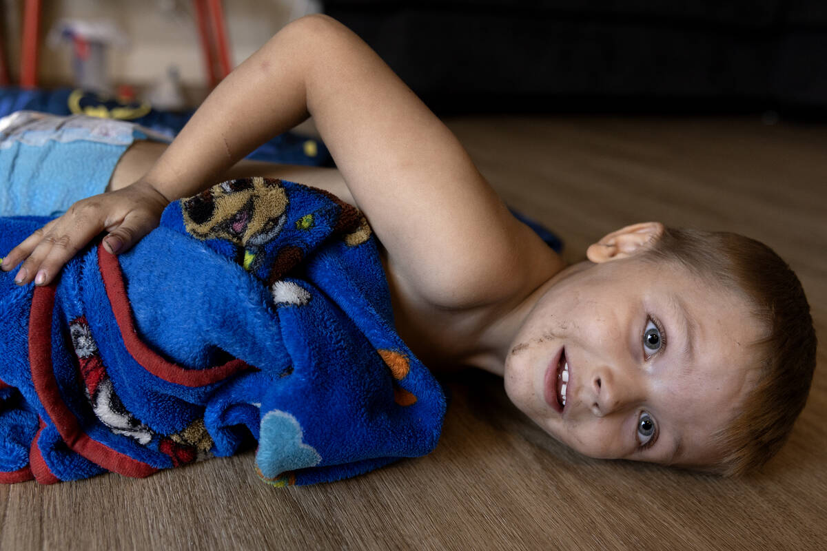 Karter Phillips, 4, whose apartment was destroyed in a June 6 fire, plays with on the floor in ...