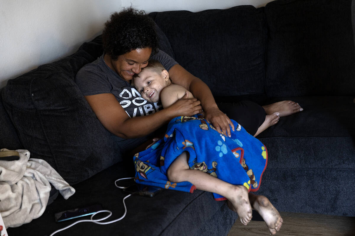 Nicole Williams hugs her son Karter Phillips, 4, in their new unit at the Tides on Charleston o ...