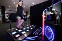 Justin Kuret of Las Vegas, shows off footwork as he plays StepManiaX, a rhythm game, at Red Not ...