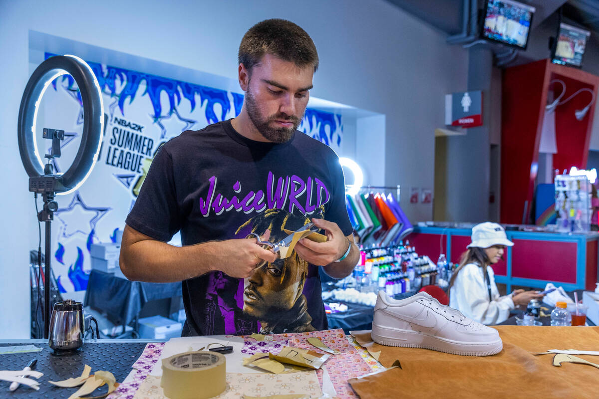 Colin Szumski cuts out custom patterns for sneakers in the Majorwavez Lab booth on the concours ...