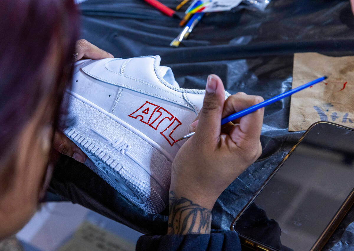 Myah Alvarado paints a custom sneaker in the Majorwavez Lab booth on the concourse during NBA S ...