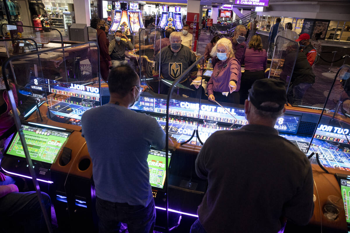 Table game dealer Valentina Chtchevelva speaks to players of the new digital craps table, Rolls ...
