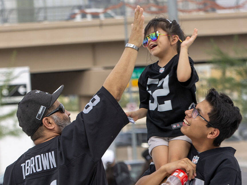 Mario Salazar high-fives his daughter Madyson Salazar, 5, who is carried by his son, Mario Sala ...
