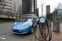 FILE - A car is parked by an electric charging station in downtown Portland, Ore., March 31, 20 ...