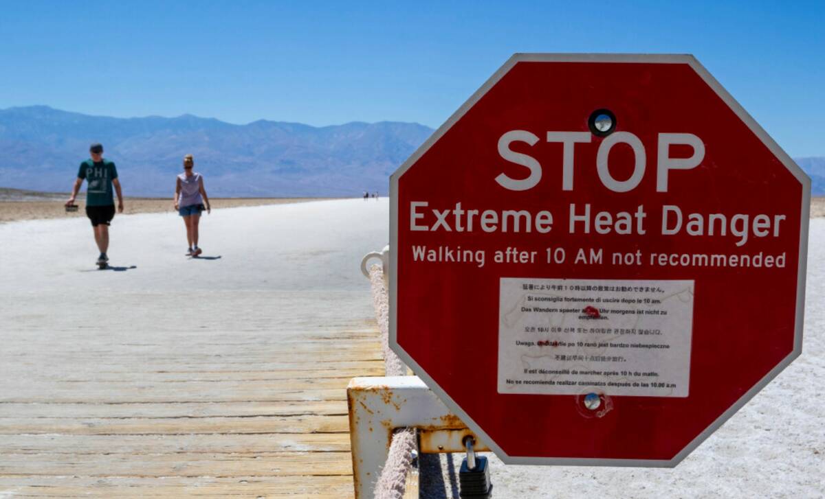 A sign warns people of extreme heat in multiple languages on Tuesday, July 11, 2023, in Death V ...