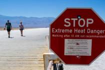 A sign warns people of extreme heat in multiple languages on Tuesday, July 11, 2023, in Death V ...