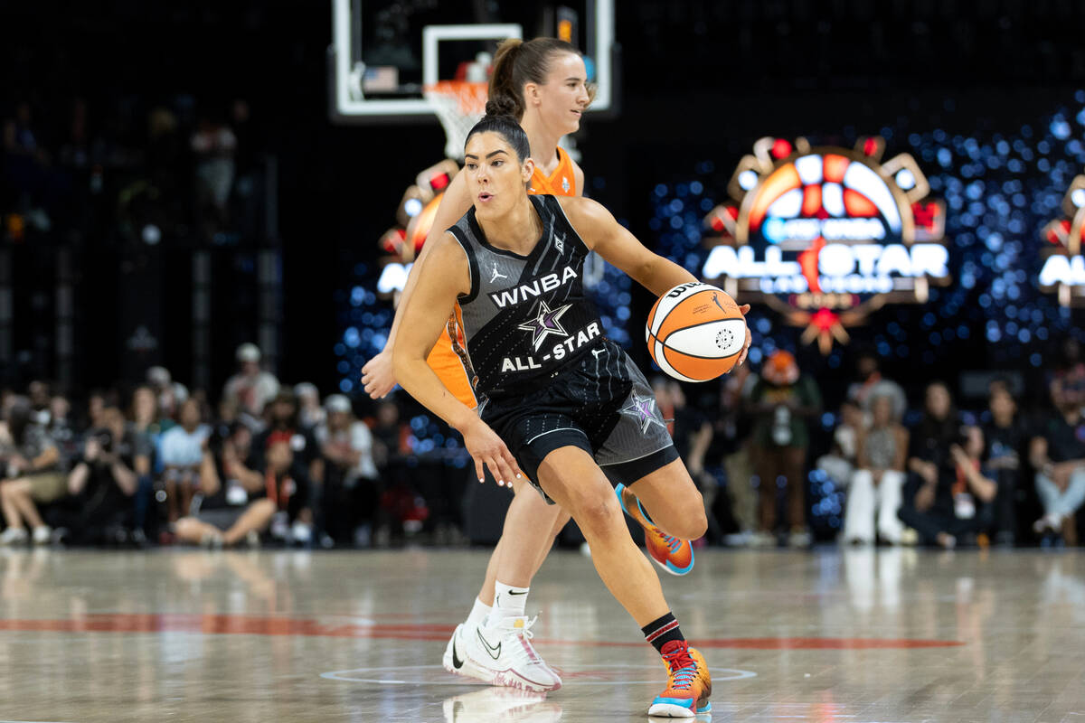 The Las Vegas Aces’ Kelsey Plum dribbles past the New York Liberty’s Sabrina Ione ...