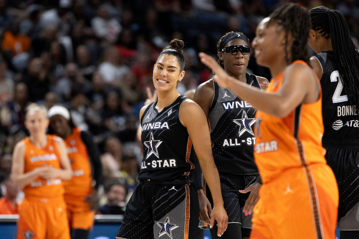 The Las Vegas Aces’ Kelsey Plum, center, laughs with Indiana Fever's Kelsey Mitchell, of ...