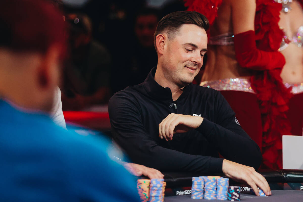 Toby Lewis smiles as he grabs a stack of his poker chips during the $10,000 buy-in No-limit Hol ...